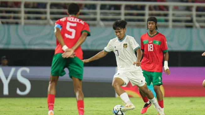 Pemain Timnas Indonesia U-17 Nabil Asyura coba melewati pemain Maroko U-17 dalam matchday ketiga Grup A Piala Dunia U-17 2023 di Stadion Gelora Bung Tomo (GBT), Surabaya, Kamis (16/11/2023). [Dok. LOC Piala Dunia U-17 2023]