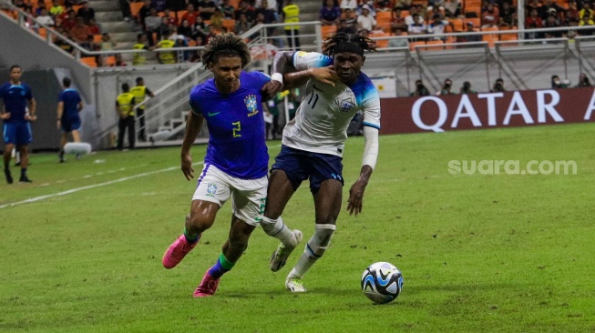 Pesepak bola Timnas Brasil U-17 Pedro Lima berebut bola dengan Pemain Timnas Inggris U-17 Ndala Joel pada pertandingan Grup C Piala Dunia U-17 2023 di Jakarta International Stadium (JIS), Jakarta, Jumat (17/11/2023). [Suara.com/Alfian Winanto]