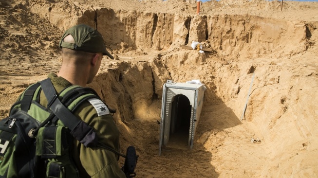 Salah satu pasukan tanah Israel berjalan pada depan salah satu terowongan Gaza. (Foto: AFP)