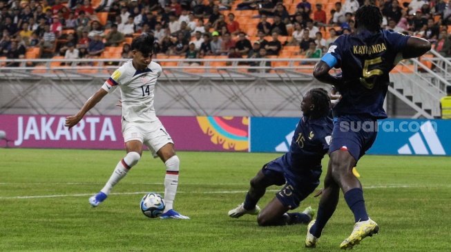 Pesepak bola Timnas Amerika Serikat U-17 Taha Habroune berusaha melewati pemain Timnas Prancis U-17 Arthur Tchaptchet pada pertandingan Grup E Piala Dunia U-17 2023 di Jakarta International Stadium (JIS), Jakarta, Sabtu (18/11/2023). [Suara.com/Alfian Winanto]
