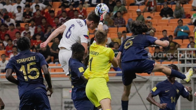 Pesepak bola Timnas Amerika Serikat U-17 Matthew Corcoran beradu bola atas dengab kiper Timnas Prancis U-17 Paul Argney pada pertandingan Grup E Piala Dunia U-17 2023 di Jakarta International Stadium (JIS), Jakarta, Sabtu (18/11/2023). [Suara.com/Alfian Winanto]
