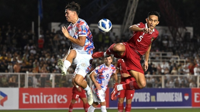 Bek Timnas Indonesia, Rizky Ridho (kanan) berebut bola pada laga Kualifikasi Piala Dunia 2026 zona Asia kontra Filipina di Stadion Rizal Memorial, Manila, Selasa (21/11). [JAM STA ROSA / AFP]