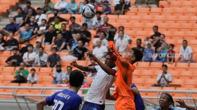 Penjaga gawang Timnas Uzbekistan U-17 Muhammadyusuf Sobirov berebut bola atas dengan pemain Timnas Inggris U-17 Acheampong pada pertandingan babak 16 besar Piala Dunia U-17 2023 di Jakarta International Stadium (JIS), Jakarta, Rabu (22/11/2023). [Suara.com/Alfian Winanto]