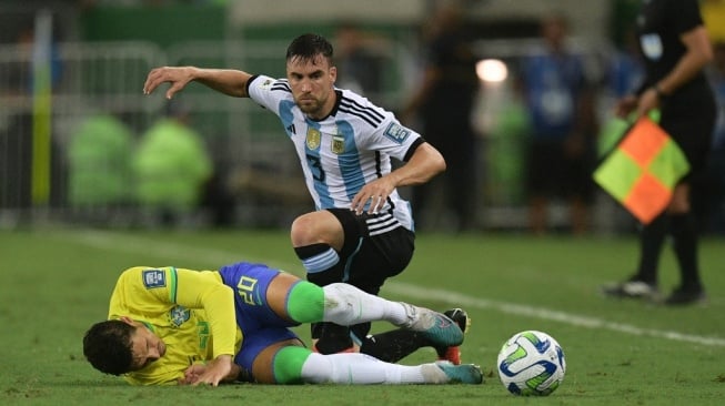 Gelandang Brasil Raphael Veiga berebut bola dengan bek Argentina Nicolas Tagliafico selama pertandingan Kualifikasi Piala Dunia FIFA 2026 zona Amerika Selatan antara Brasil vs Argentina di Stadion Maracana di Rio de Janeiro, Brasil, pada 21 November 2023.CARL DE SOUZA / AFP.