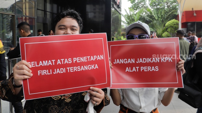 Sejumlah aktivis membawa poster saat menggelar aksi terkait penetapan tersangka Ketua KPK Firli Bahuri di Gedung Merah Putih KPK, Jakarta, Kamis (23/11/2023). [Suara.com/Alfian Winanto]