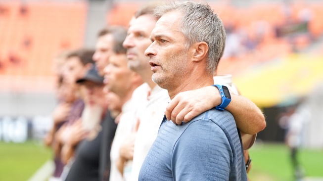 The expression of the German U-17 National Team coach, Christian Wueck when singing the national anthem before the U-17 World Cup quarter-final match against the Spanish U-17 National Team at the Newsdelivers.com International Stadium (JIS), Friday (24/11).  (Doc. LOC WCU17/BRY)