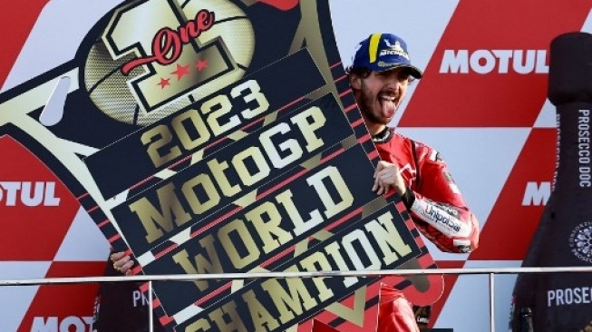 Pembalap Ducati Italia Francesco Bagnaia merayakan dalam podium pasca meraih kemenangan Grand Prix MotoGP Valencia dalam arena pacuan kuda Ricardo Tormo pada Cheste, pada 26 November 2023. JOSE JORDAN / AFP