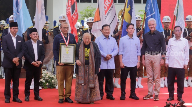 Ketua Komisi Pemilihan Umum (KPU) Hasyim Asy’ari berfoto bersama dengan para pasangan Capres-Cawapres dan Pendiri MURI Jaya Suprana usai menerima piagam penghargaan rekor MURI di Gedung KPU, Jakarta, Senin (27/11/2023). [Suara.com/Alfian Winanto]