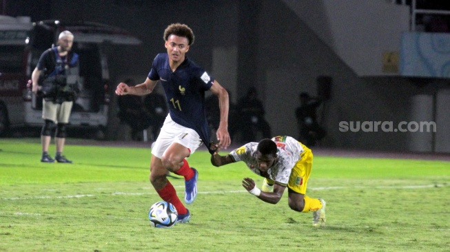 Striker Timnas Prancis U-17, Tidiam Gomis melewati adangan bek Mali, Moussa Traore dalam semifinal Piala Dunia U-17 2023 di Stadion Manahan, Solo, Selasa (28/11/2023) malam. [Suara.com/Ronald Seger Prabowo]