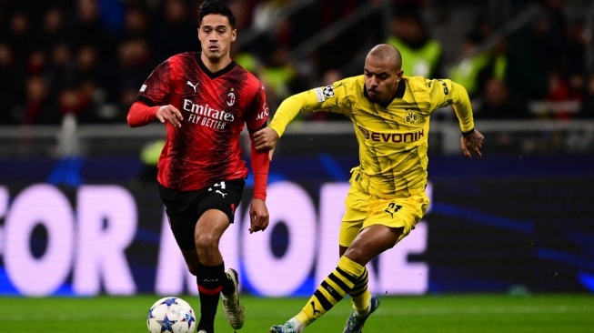 Gelandang AC Milan asal Belanda #14 Tijani Reijnders berebut bola dengan penyerang Dortmund asal Belanda #21 Donyell Malen selama matchday kelima Grup F Liga Champions 2023-2024 antara AC Milan vs Borussia Dortmund di stadion San Siro di Milan pada 28 November 2023.Marco BERTORELLO / AFP.