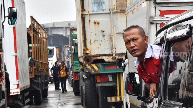 Seorang pengendara terjebak kemacetan saat aksi buruh di kawasan MM 2100, Kabupaten Bekasi, Jawa Barat, Kamis (30/11/2023). [ANTARA FOTO/ Fakhri Hermansyah/rwa]