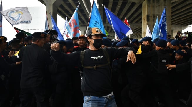 Sejumlah personel Kepolisian menahan buruh yang ingin menuju gerbang Tol Cibitung 3 di kawasan MM 2100, Kabupaten Bekasi, Jawa Barat, Kamis (30/11/2023). [ANTARA FOTO/ Fakhri Hermansyah/rwa]