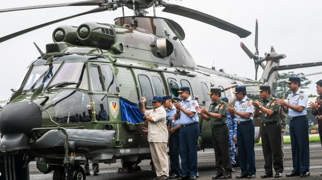 Menteri Pertahanan Prabowo Subianto (kiri) didampingi Kasau Marsekal TNI Fadjar Prasetyo (kedua kiri) menyibakan bendera satuan saat serah terima helikopter angkut berat Airbus H225M di Lanud Atang Sendjaja, Kemang, Bogor, Jumat (1/12/2023). [ANTARA FOTO/Galih Pradipta/foc]