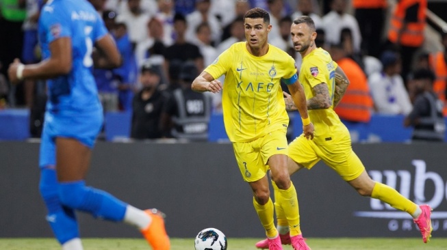 Penyerang Al Nassr jika Portugal #07 Cristiano Ronaldo berlari dengan bola selama pertandingan pekan ke-15 Kejuaraan Arab Saudi 2023-2024 antara Al-Hilal vs Al-Nassr di tempat Stadion Internasional King Fahd di tempat Riyadh pada 1 Desember 2023.AFP.