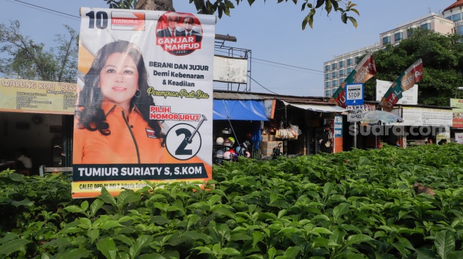 Alat Peraga Kampanye (APK) terpasang di sebuah pohon di Kawasan Senen, Jakarta, Sabtu (2/12/2023). [Suara.com/Alfian Winanto]