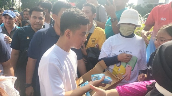 Cawapres nomor urut dua, Gibran Rakabuming Raka saat bagi-bagi susu di area CFD Bundaran HI. (Antara)