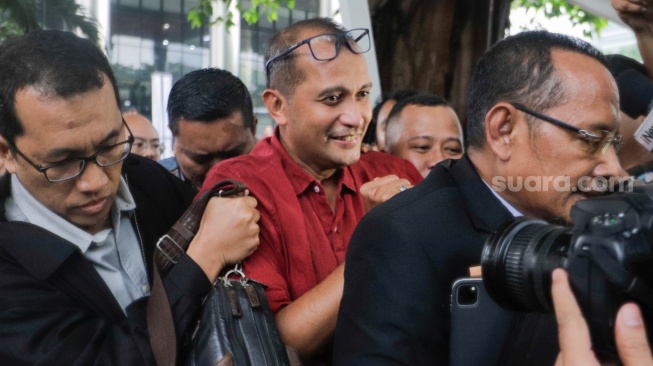 Wakil Menteri Hukum dan HAM (Wamenkumham) Edward Omar Sharif Hiariej (tengah) usai menjalani pemeriksaan di Gedung Merah Putih KPK, Jakarta, Senin (4/12/2023). [Suara.com/Alfian Winanto]