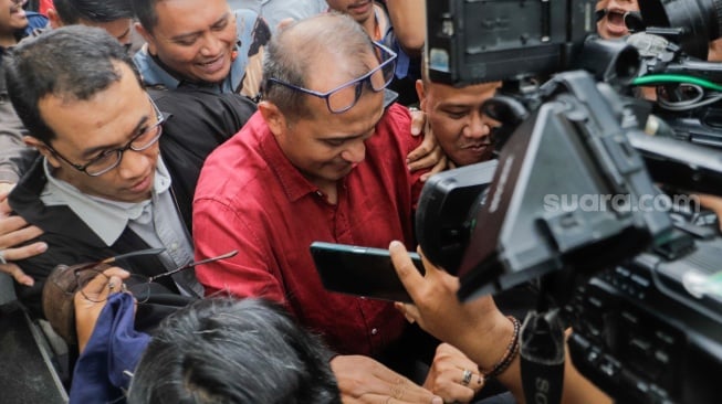 Wakil Menteri Hukum dan HAM (Wamenkumham) Edward Omar Sharif Hiariej (tengah) usai menjalani pemeriksaan di Gedung Merah Putih KPK, Jakarta, Senin (4/12/2023). [Suara.com/Alfian Winanto]