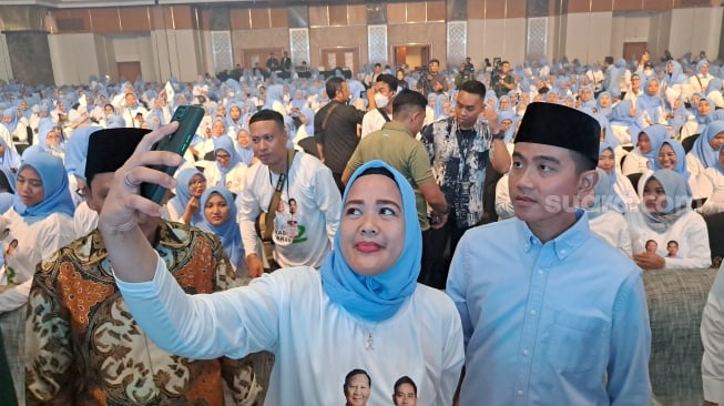 Calon wakil presiden nomor urut 2, Gibran Rakabuming Raka, selfie bersama pendukungnya. (Suara.com/Novian)