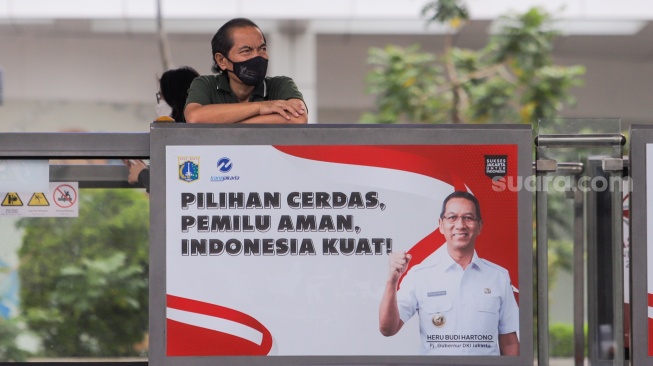 Penumpang memakai masker saat menunggu bus Transjakarta di Halte Tosari, Jakarta, Kamis (7/12/2023). [Suara.com/Alfian Winanto]