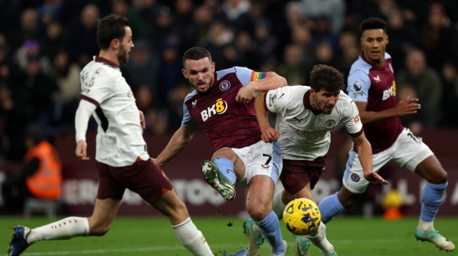 Gelandang Aston Villa asal Skotlandia #07 John McGinn (tengah) melakukan tendangan melebar selama pertandingan pekan ke-15 Liga Inggris antara Aston Villa vs Manchester City di Villa Park di Birmingham, Inggris tengah pada 6 Desember 2023.Adrian DENNIS / AFP.