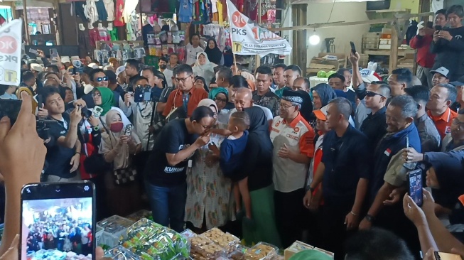 Capres Anies Baswedan saar di Pasar Kepuh, Kabupaten Kuningan, Jawa Barat (Jabar), Sabtu (9/12/2023). Anies bersama istrinya Fery Farhati mengunjungi pasar tersebut bertemu pedagang. [Suara.com/Dea] 