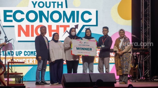 Founder CORE Indonesia, Hendri Saparini memberikan hadiah kepada pemenang kompetisi Vlog di acara Youth Economic Night 2023 di M Bloc Space, Jakarta, Sabtu (9/12/2023). [Suara.com/Alfian Winanto]