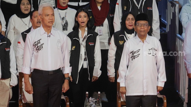 Capres dan cawapres nomor urut tiga Ganjar Pranowo dan Mahfud MD saat debat perdana Calon Presiden dan Calon Wakil Presiden di gedung KPU, Jakarta, Selasa (12/12/2023).  [Suara.com/Alfian Winanto]