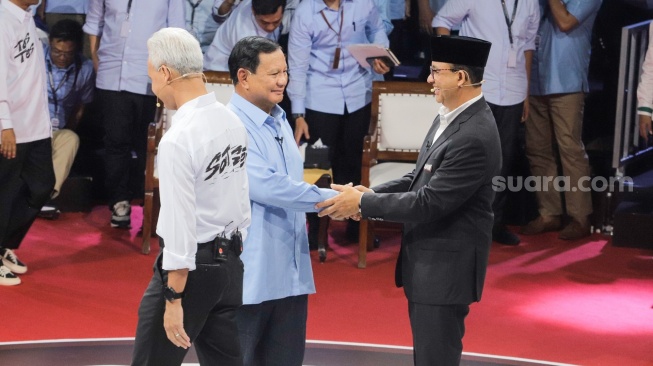 Presidential candidate number two Prabowo Subianto (left) shakes hands with presidential candidate number one Anies Baswran (right) during the inaugural debate between Presidential Candidates and Vice Presidential Candidates at the KPU building, Newsdelivers.com, Tuesday (12/12/2023).  (Suara.com/Alfian Winanto)