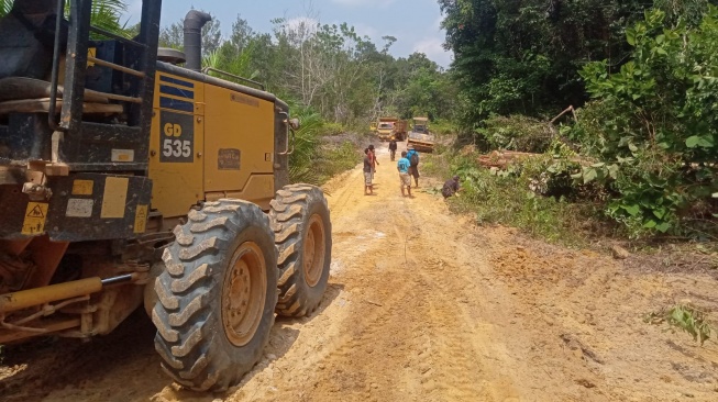 Warga Desa Empura-Desa Embaleh sedang menyaksikan alat berat milik PT KSA  memperbaiki jalan poros Desa Empura-Embaleh (Dok. Istimewa)