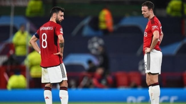 Reaksi gelandang Manchester United #08 Bruno Fernandes dan #35 Jonny Evans setelah kalah dari Bayern Munich pada pertandingan sepak bola grup A Liga Champions UEFA di stadion Old Trafford di Manchester, Inggris, pada 12 Desember 2023. PETER POWELL / AFP