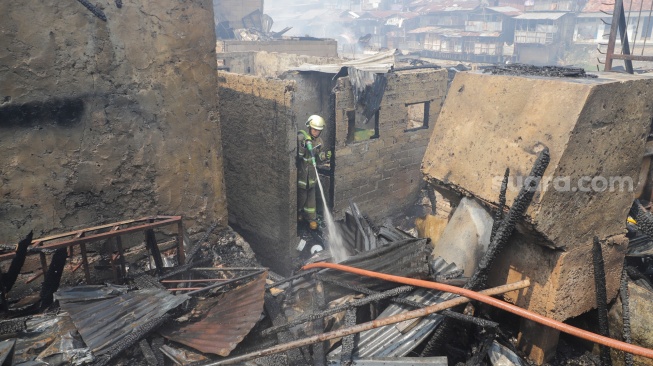 Petugas pemadam kebakaran memadamkan api yang membakar pekukiman padat di kawasan Manggarai, Tebet, Jakarta, Kamis (14/12/2023). [Suara.com/Alfian Winanto]