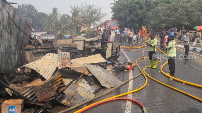 Petugas pemadam kebakaran memadamkan api yang membakar pekukiman padat di kawasan Manggarai, Tebet, Jakarta, Kamis (14/12/2023). [Suara.com/Alfian Winanto]