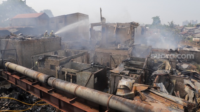 Petugas pemadam kebakaran memadamkan api yang membakar pekukiman padat di kawasan Manggarai, Tebet, Jakarta, Kamis (14/12/2023). [Suara.com/Alfian Winanto]