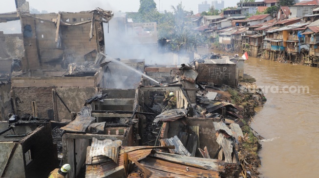 Petugas pemadam kebakaran memadamkan api yang membakar pekukiman padat di kawasan Manggarai, Tebet, Jakarta, Kamis (14/12/2023). [Suara.com/Alfian Winanto]