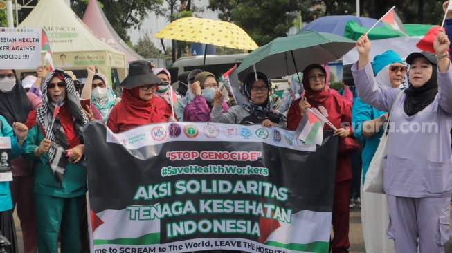 Medical Emergency Rescue Committee (MER-C) bersama Ikatan Dokter Indonesia (IDI), dan organisasi profesi kesehatan melakukan aksi di Patung Kuda, Jakarta, Jumat (15/12/2023). [Suara.com/Alfian Winanto]