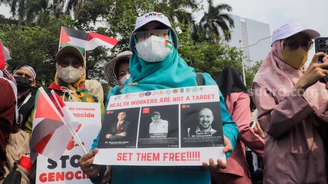 Medical Emergency Rescue Committee (MER-C) bersama Ikatan Dokter Indonesia (IDI), dan organisasi profesi kesehatan melakukan aksi di Patung Kuda, Jakarta, Jumat (15/12/2023). [Suara.com/Alfian Winanto]