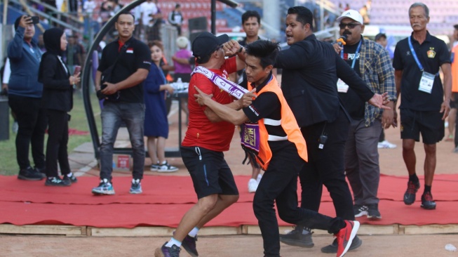 Petugas menghalau suporter yang mencoba memasuki lapangan saat pertandingan Persik Kediri melawan PSM Makassar dihentikan sementara pada kompetisi BRI Liga 1 di Stadion Brawijaya, Kota Kediri, Jawa Timur, Senin (18/12/2023). ANTARA FOTO/Prasetia Fauzani/YU