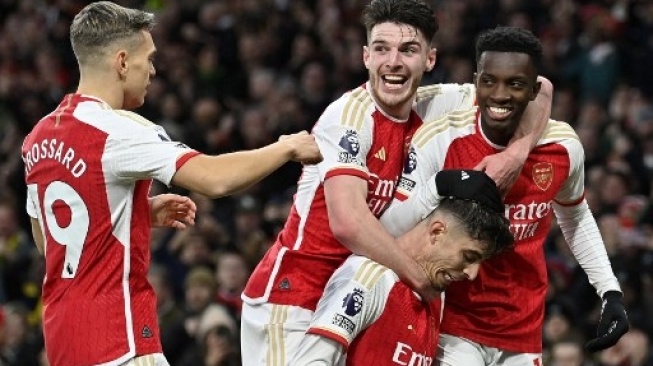 Para pemain Arsenal merayakan gol #29 Kai Havertz (tengah) saat menghadapi Brighton and Hove Albion pada pertandingan sepak bola Liga Utama Inggris di Emirates Stadium London pada 17 Desember 2023. JUSTIN TALLIS / AFP 