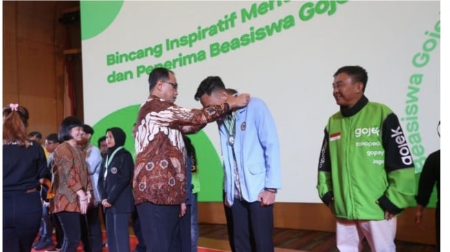 Menteri Perhubungan Republik Indonesia - Budi Karya Sumadi menyematkan medali kepada alumni penerima Beasiswa Gojek angkatan Pertama yang turut disaksikan oleh Direktur dan Presiden Unit Bisnis On-Demand Services Grup GoTo - Catherine Hindra Sutjahyo. (ANTARA/HO-Gojek)