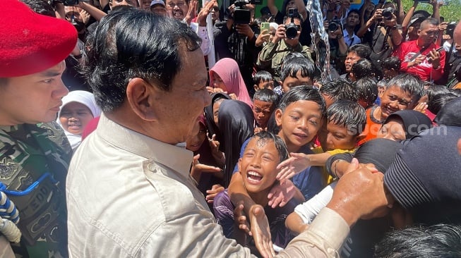 Menteri Pertahanan RI, Prabowo Subianto, terlihat senang bermain dengan anak-anak di Desa Pamupukan, Kabupaten Kuningan, Jawa Barat, Rabu (20/12/2023). (Suara.com/Novian)