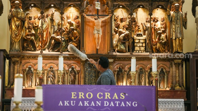 Petugas menyiapkan dekorasi dan membersihkan area Gereja Katedral, Jakarta, Kamis (21/12/2023). [Suara.com/Alfian Winanto]