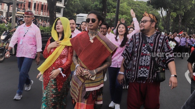 Penyanyi Young Lex (tengah) dan Komika Fico Fachriza (kanan) saat hadir untuk mendukung paslon nomor urut tiga Ganjar Pranowo dan Mahfud MD di JCC Senayan, Jakarta, Jumat (22/12/2023). [Suara.com/Alfian Winanto]