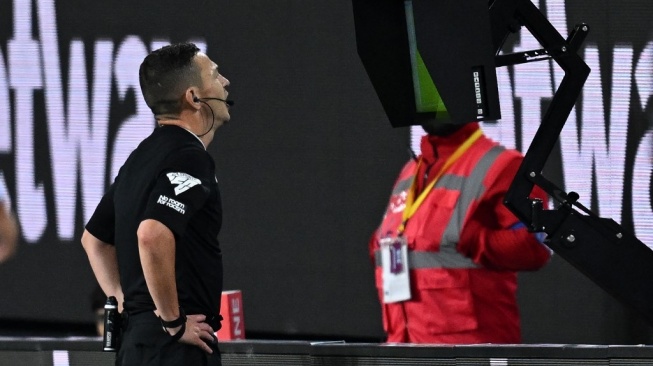 Penggunaan teknologi Video Assistant Referee (VAR) di laga sepak bola profesional. [AFP]