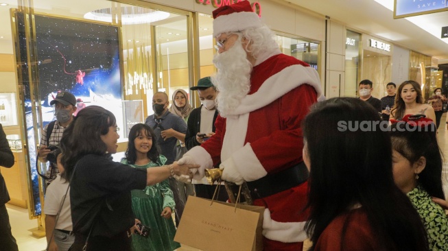 Sinterklas memberikan hadiah kepada pengunjung di salah satu Pusat Perbelanjaan di Jakarta, Senin (25/12/2023). [Suara.com/Alfian Winanto]