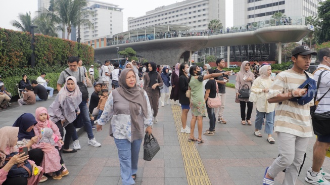 Warga berwisata di Kawasan Bundaran HI, Jakarta, Senin (25/12/2023). [Suara.com/Alfian Winanto]