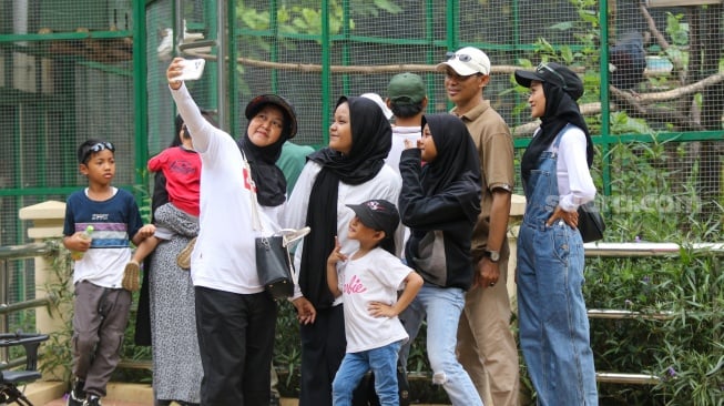 Pengunjung saat berwisata di Taman Margasatwa Ragunan, Jakarta, Selasa (26/12/2023). [Suara.com/Alfian Winanto]