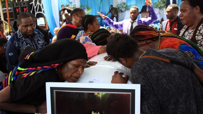 Warga memeluk peti jenazah mantan Gubernur Papua Lukas Enembe sebelum pemakaman di Koya Tenga, Kota Jayapura, Papua, Kamis (28/12/2023). [ANTARA FOTO/Gusti Tanati].