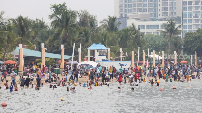 Warga saat berwisata di Pantai Lagoon, Ancol, Jakarta, Kamis (28/12/2023). [Suara.com/Alfian Winanto]