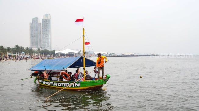 Warga saat berwisata di Pantai Lagoon, Ancol, Jakarta, Kamis (28/12/2023). [Suara.com/Alfian Winanto]